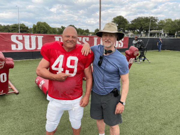 Two men standing next to each other on a field.