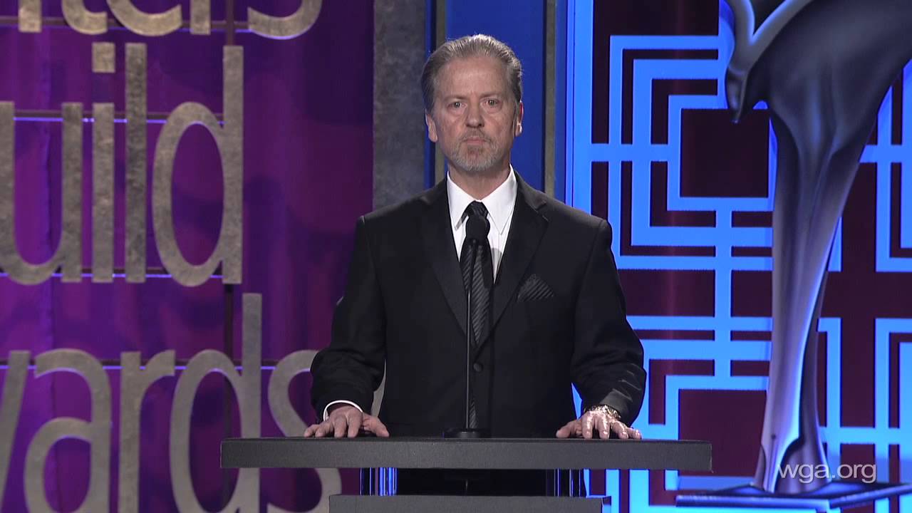 A man in a suit and tie standing at a podium.